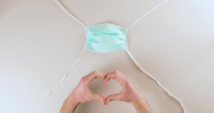 Coronavirus fine della pandemia, successo con simbolo del cuore da parte di un medico con mascherina. Virus definitivamente debellato.