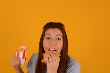 woman eating a burger on a yellow background fast food