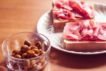 Green olives and toast with serrano ham, traditional spanish snack