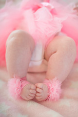 Obraz na płótnie Canvas legs of a little baby girl in a pink skirt