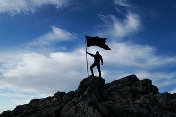 Man with flag on top of the mountain against the sky. Concept business ideas, success and...
