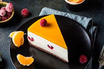 No Bake mango Cheesecake Decorated with Fresh raspberry and tangerine. Healthy dessert. Vegetarian...