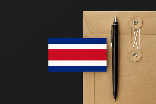 Costa Rica flag on craft envelope letter and black pen background. National invitation concept. Invitation for education theme.