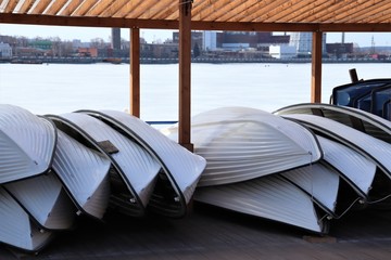 Boats are piled upside down under a canopy.