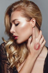 Obraz premium young blonde woman posing with lipstick mark on hand