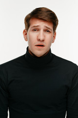 young sad man on white studio background