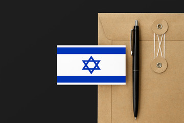 Israel flag on craft envelope letter and black pen background. National invitation concept. Invitation for education theme.