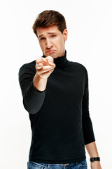 man pointing with finger at camera on white studio background