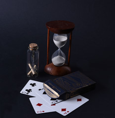 hourglass with sand and playing cards