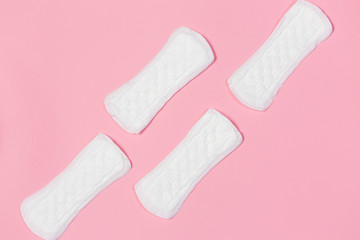 White feminine pads on a pink background