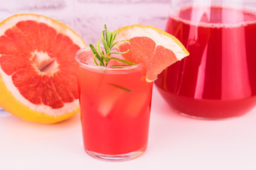 
Grapefruit juice in a glass on a white background. A concept of healthy refreshing drinks.