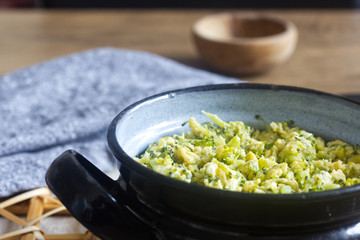 Healthy lunch with broccoli and eggs in black pot.
