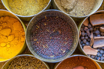 close-up of metal canisters with spices of different colors and textures