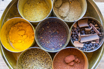 close-up of metal canisters with spices of different colors and textures