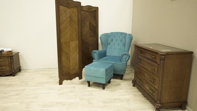 Blue stylish chair with an ottoman wooden screen and chest of drawers solid oak.