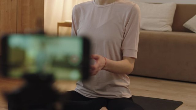 CU Attractive Caucasian female recording making live stream or vlog about doing yoga at home. Stay home, quarantine workout. Shot on ARRI Alexa Mini with Cooke S4 lenses