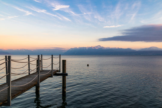 Coucher de soleil sur le Lac L&eacute;man et les montagnes des Alpes &agrave; Morges avec au premier plan un ponton (Suisse)
