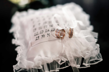 Wedding rings on the lace pillow with reflection 