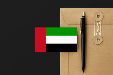 United Arab Emirates flag on craft envelope letter and black pen background. National invitation concept. Invitation for education theme.