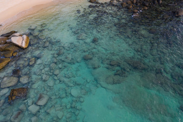 Aerial drone view of crystal clear turquoise sea water and rocks