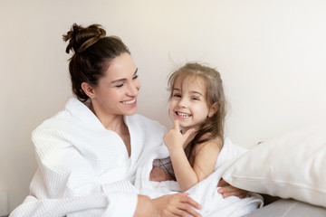 Mother with little smiling daughter in towel. 