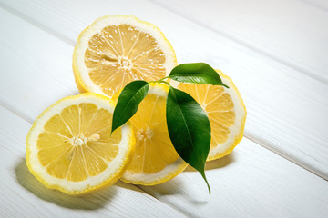 Fresh juicy lemons on a white wooden cutting board background