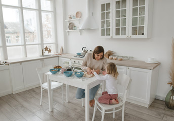 A young mother spends time with her little daughter at home.