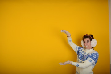 cute young woman in a sweater holds hands free space
