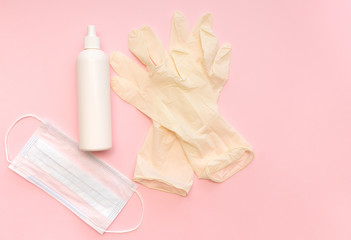 medical gloves, medical mask, antiseptic on a pink background close-up