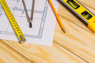 Accessories and drawing tools lie on a building project or wooden boards