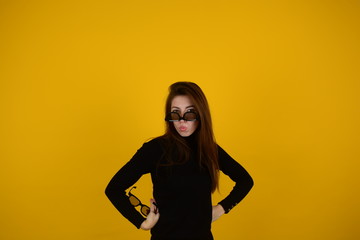 Fototapeta na wymiar woman in 3D glasses with emotions on her face on a yellow background
