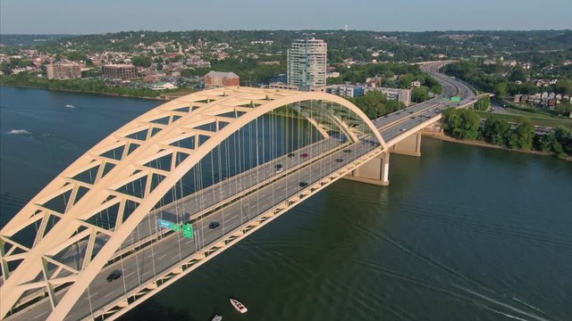 Aerial: Freeway traffic crossing the Daniel Carter Beard Bridge over the Ohio River. With the city skyline of Coventry., kentucky