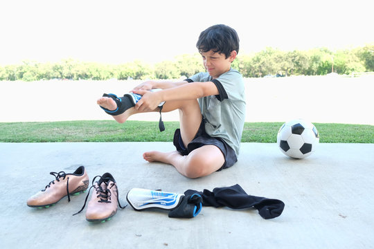 Male child soccer player dressing in a hurry for a game