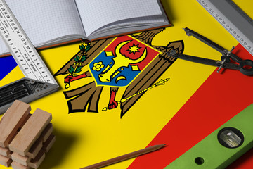 Moldova national flag on profession concept with architect desk and tools background. Top view mock-up.