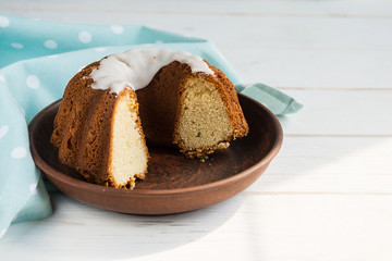 Delicious sweet cottage cheese Easter cupcake in a brown clay plate on a white plate with a blue napkin. Baking for the holiday of Holy Easter.