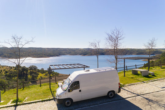Camper van with solar panel drone aerial view in Odeleite dam reservoir landscape living van life on the countryside in Alentejo, Portugal