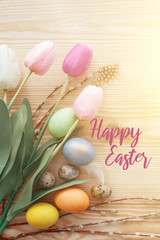 Easter eggs and tulips on a wooden table. Morning light.