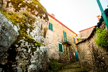 Houses between rocks on the mountain in a medieval village of Monsanto, made of stone and with red roofs, Portugal, in winter