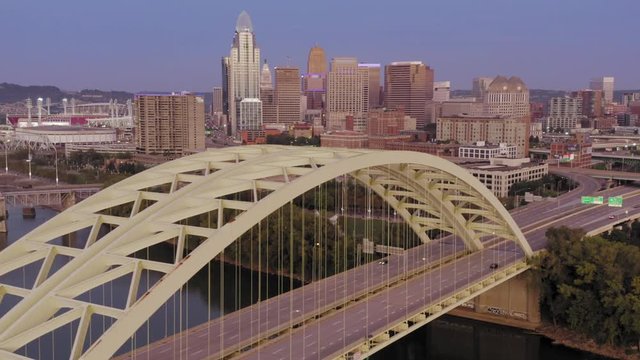 Aerial: Freeway traffic crossing the Daniel Carter Beard Bridge over the Ohio River. Cincinnati city skyline is in the distance, Ohio