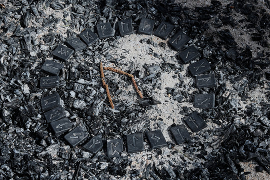Norse rune Uruz on ashes backgorund inside the circle of 24 Norse runes