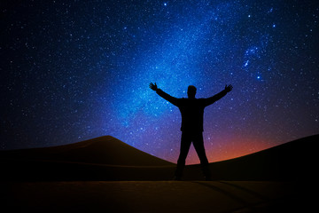 Man in front of the universe with his arms raised