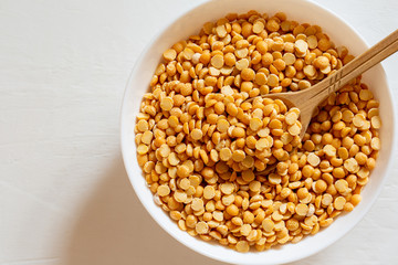 Yellow split peas in a bowl on a white background. Dry cereal for cooking.