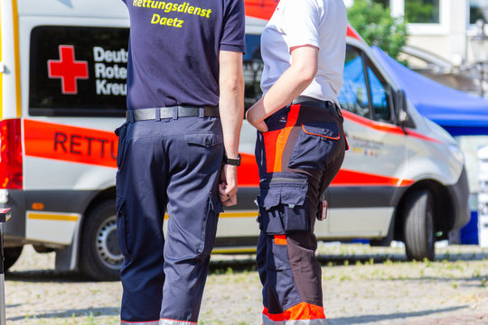 PEINE / GERMANY - JUNE 22, 2019: German female paramedic stands in front of an ambulance car. Rettungsdienst means ambulance service.