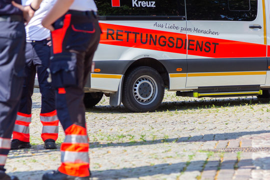 PEINE / GERMANY - JUNE 22, 2019: German female paramedic stands in front of an ambulance car. Rettungsdienst means ambulance service.