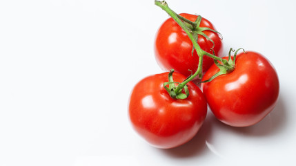 three tomatoes lying on a white background