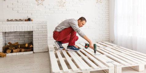 Construction of bed. The man puts the bed frame.