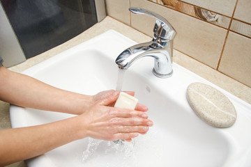 A Hands with soap are washed under the tap with water. Clean from infection and dirt and virus. At...