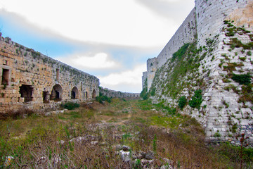 Krak (Crac) des Chevaliers, also called (‎Castle of the Kurds), and formerly Crac de l'Ospital, is a Crusader castle in Syria and one of the most important preserved medieval castles in the world. - obrazy, fototapety, plakaty