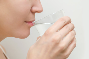 healthy young attractive woman drinking clean water from a clear glass	