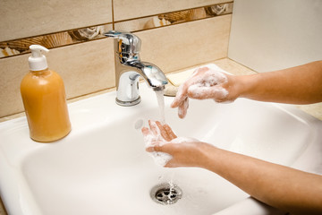 Hands with soap are washed under the tap with water. Clean from infection and dirt and virus.